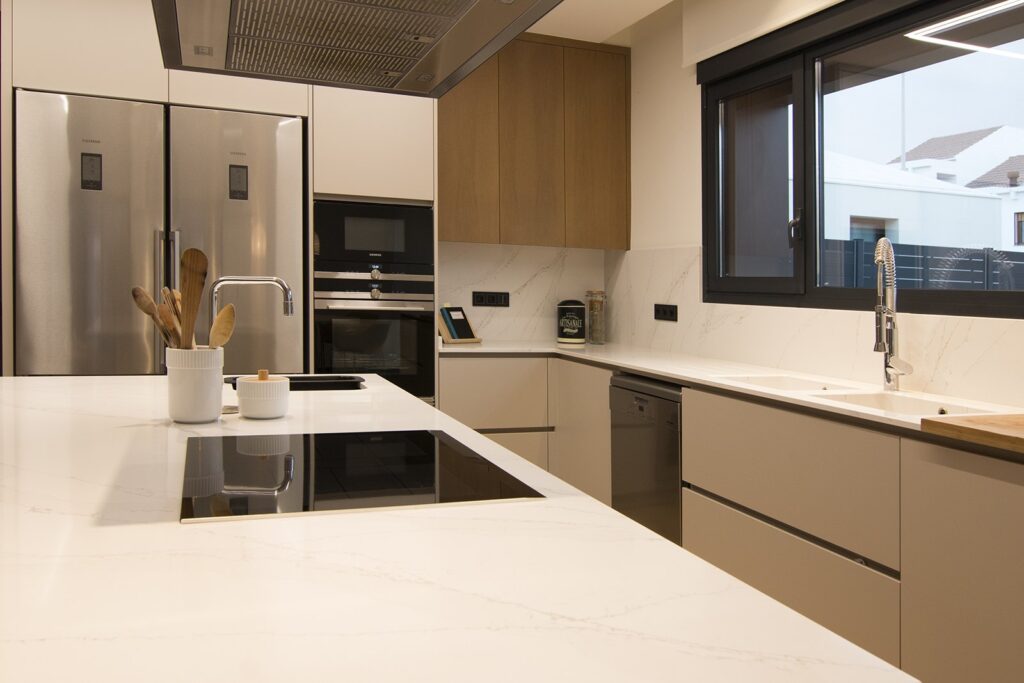 Cocina con columnas de electrodomésticos y altos de madera