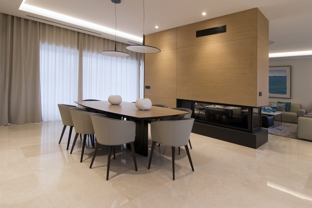 Comedor del chalet con chimenea revestida de madera
