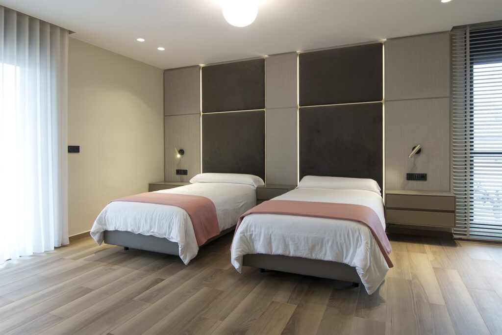 Dormitorio con cabecero de paneles tapizados y empapelados con LED