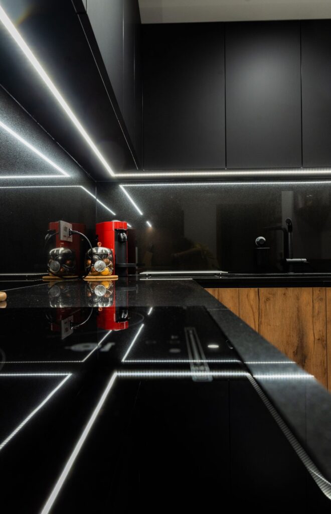 Tira LED bajo los muebles altos reflejada en el granito