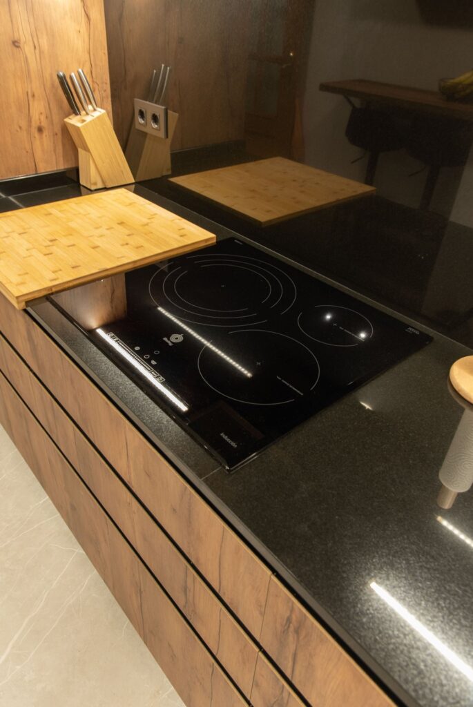 Placa de inducción y bajos en madera con uñero negro
