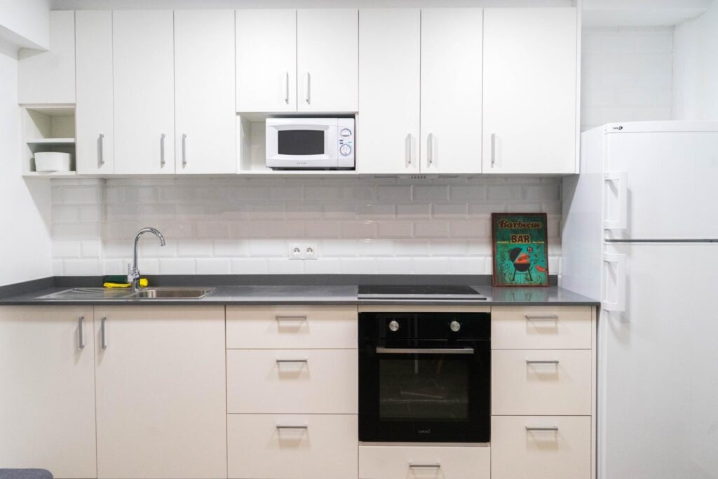 Cocina blanca con horno y encimera oscura