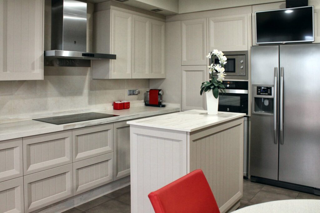 Cocina con frigorífico americano y columna de hornos