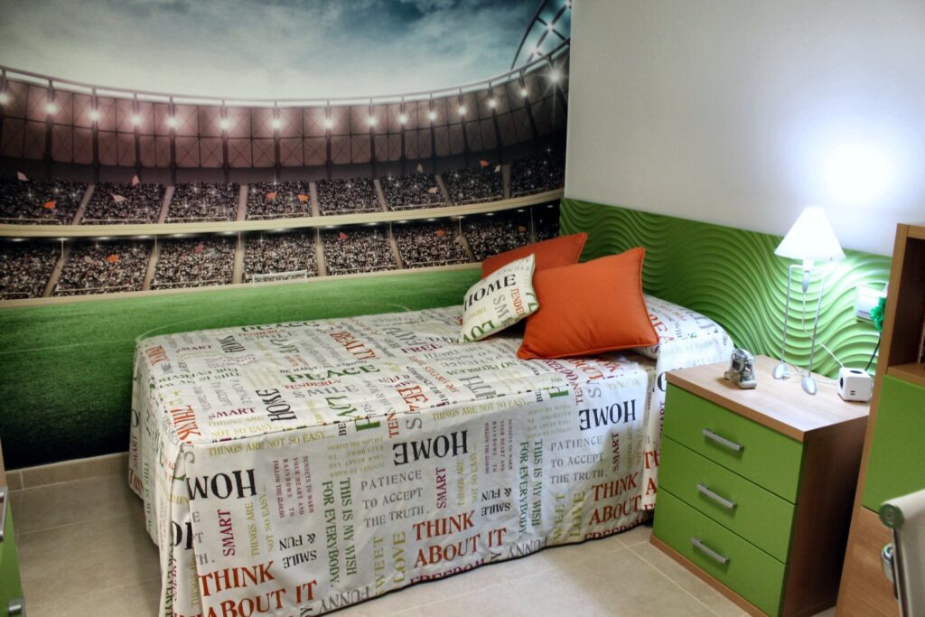 Dormitorio juvenil con cajonera verde y mural de estadio