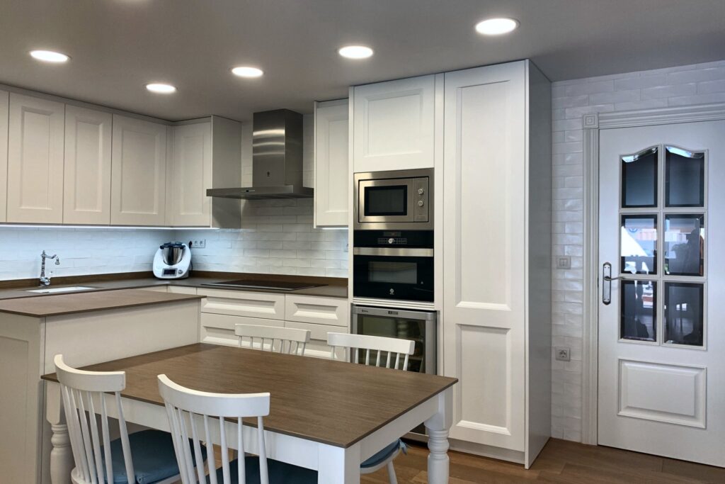 Cocina con mesa central y columnas lacadas en blanco