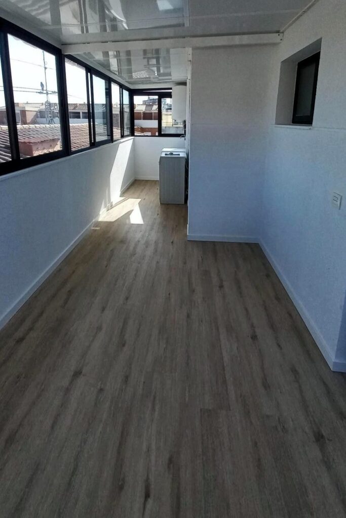 Terraza cerrada con aluminio negro y suelo vinílico