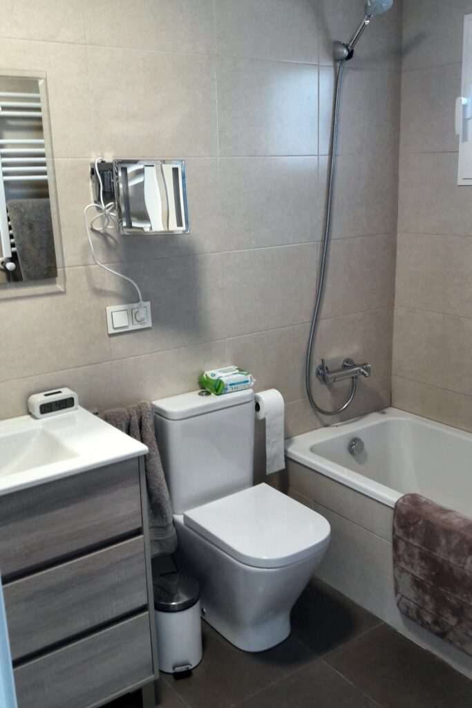 Baño con bañera, inodoro y mueble de lavabo