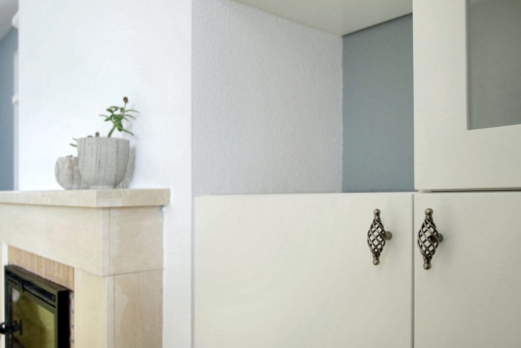 Mueble lacado en blanco junto a la chimenea