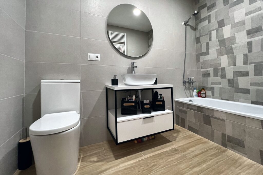 Baño con bañera chapada y mueble con estructura de hierro