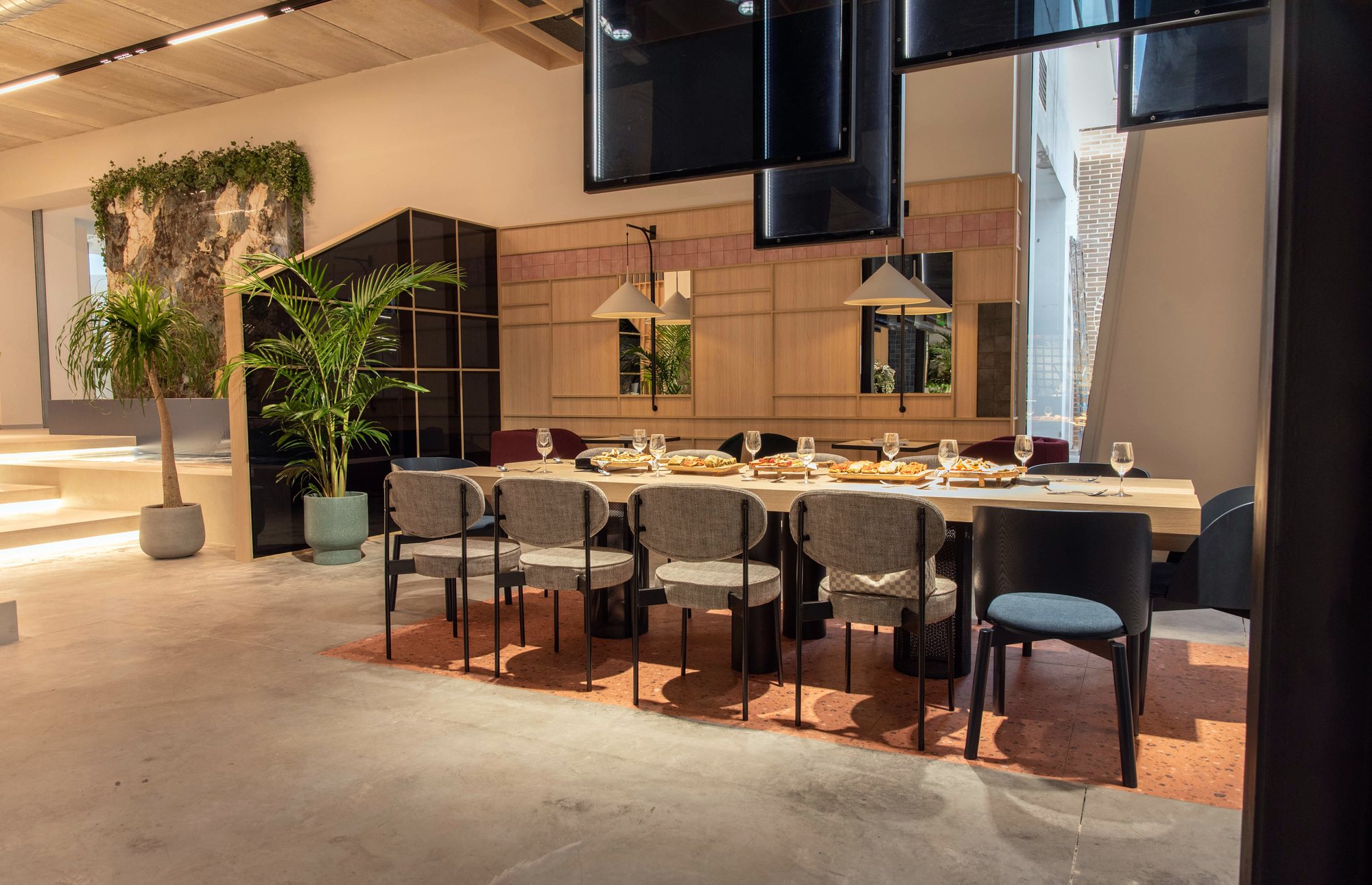 Zona de comedor con mesa larga bajo techo de madera