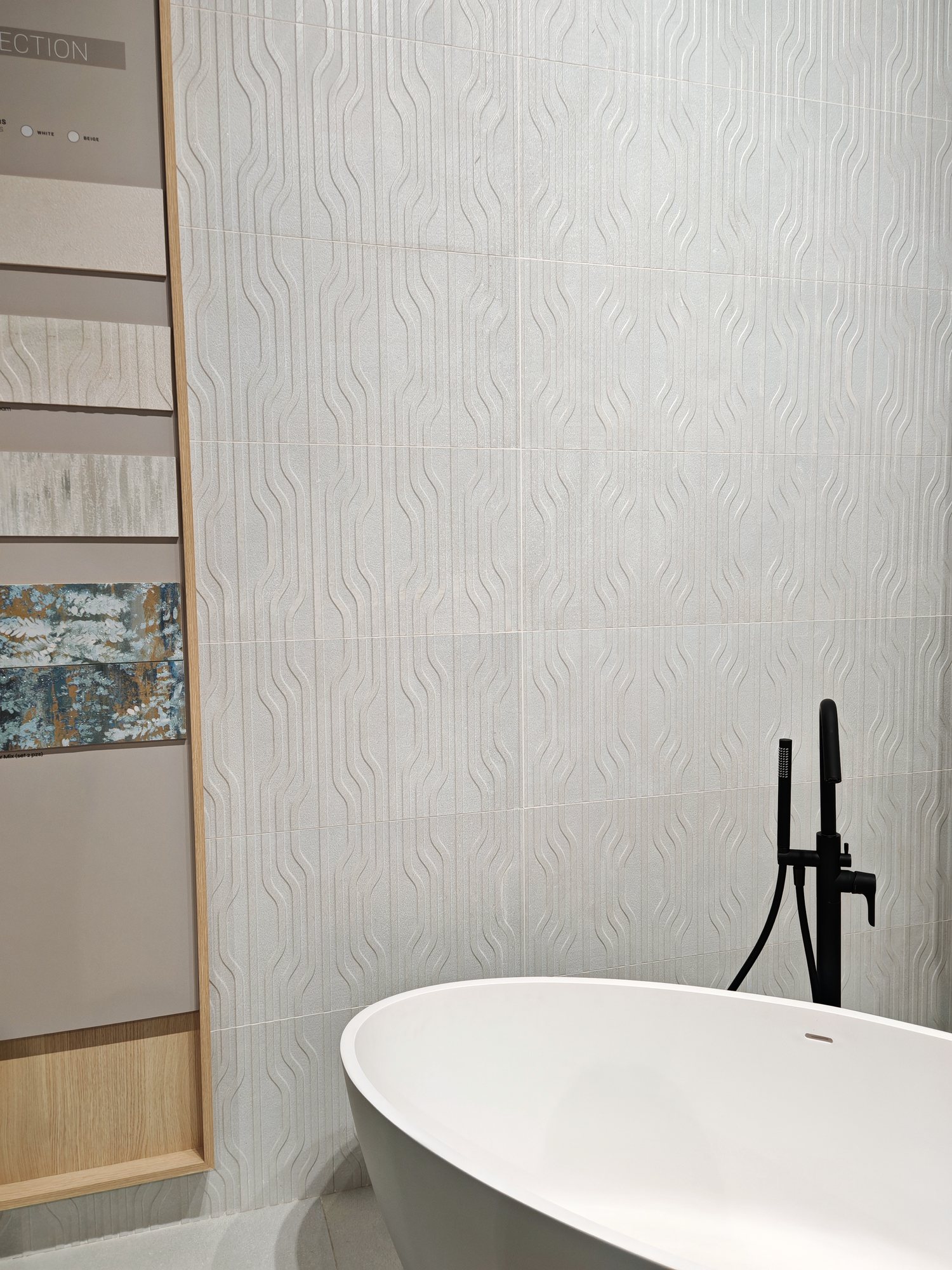 Ambiente de baño con bañera exenta y pared en relieve