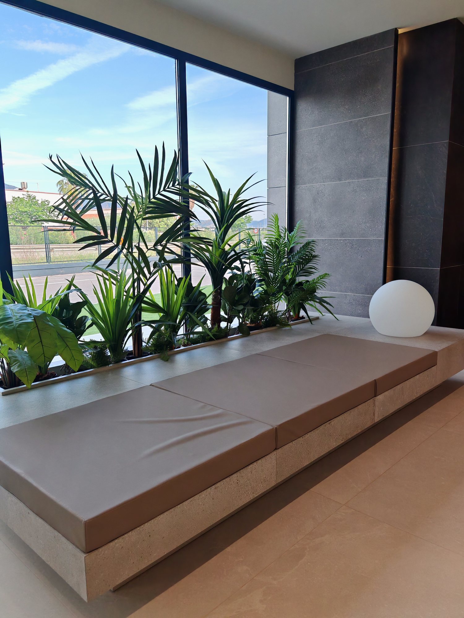Jardinera con banco junto a la cristalera