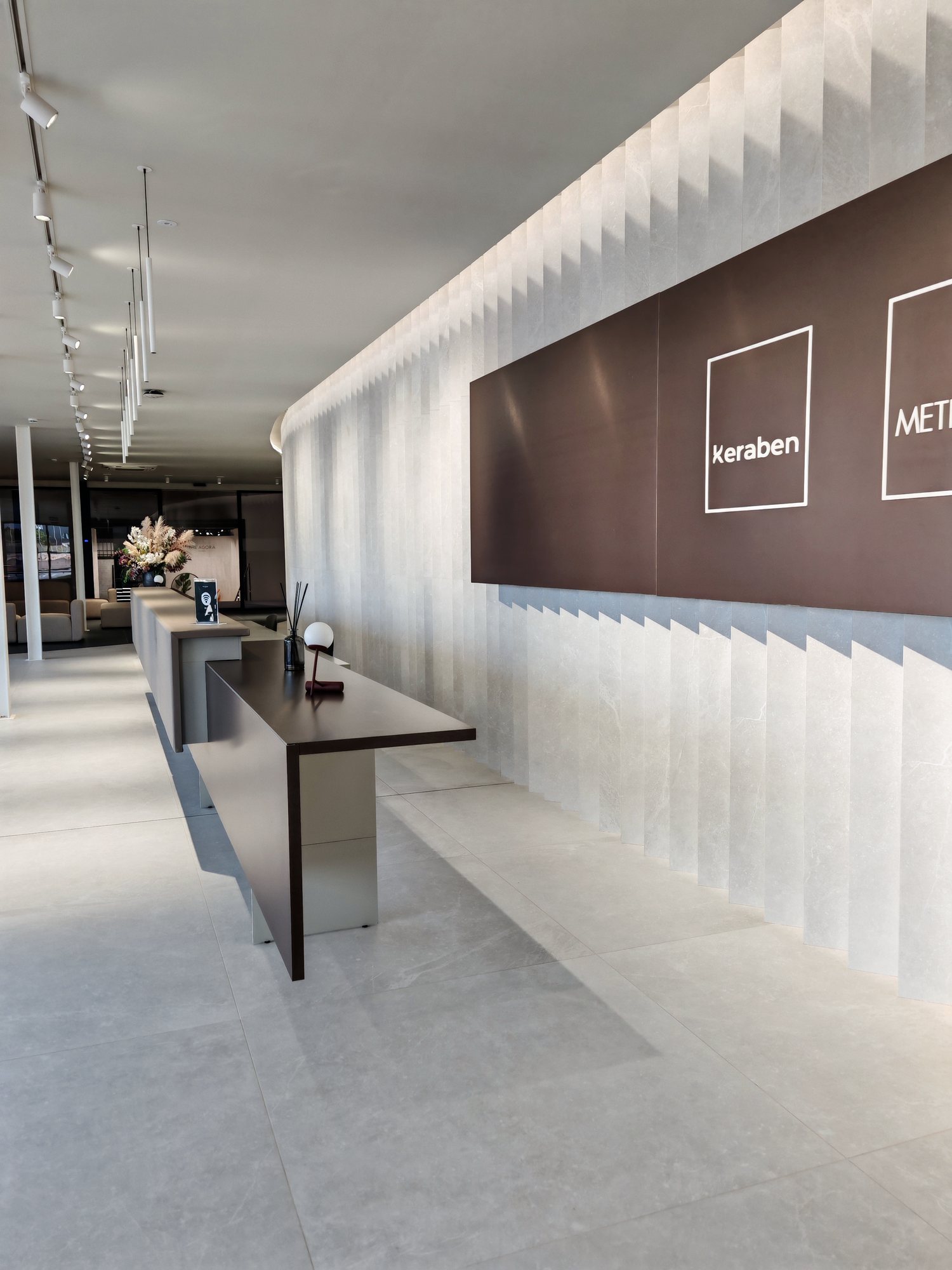 Recepción del showroom de Keraben Grupo con mostrador y pared de prismas