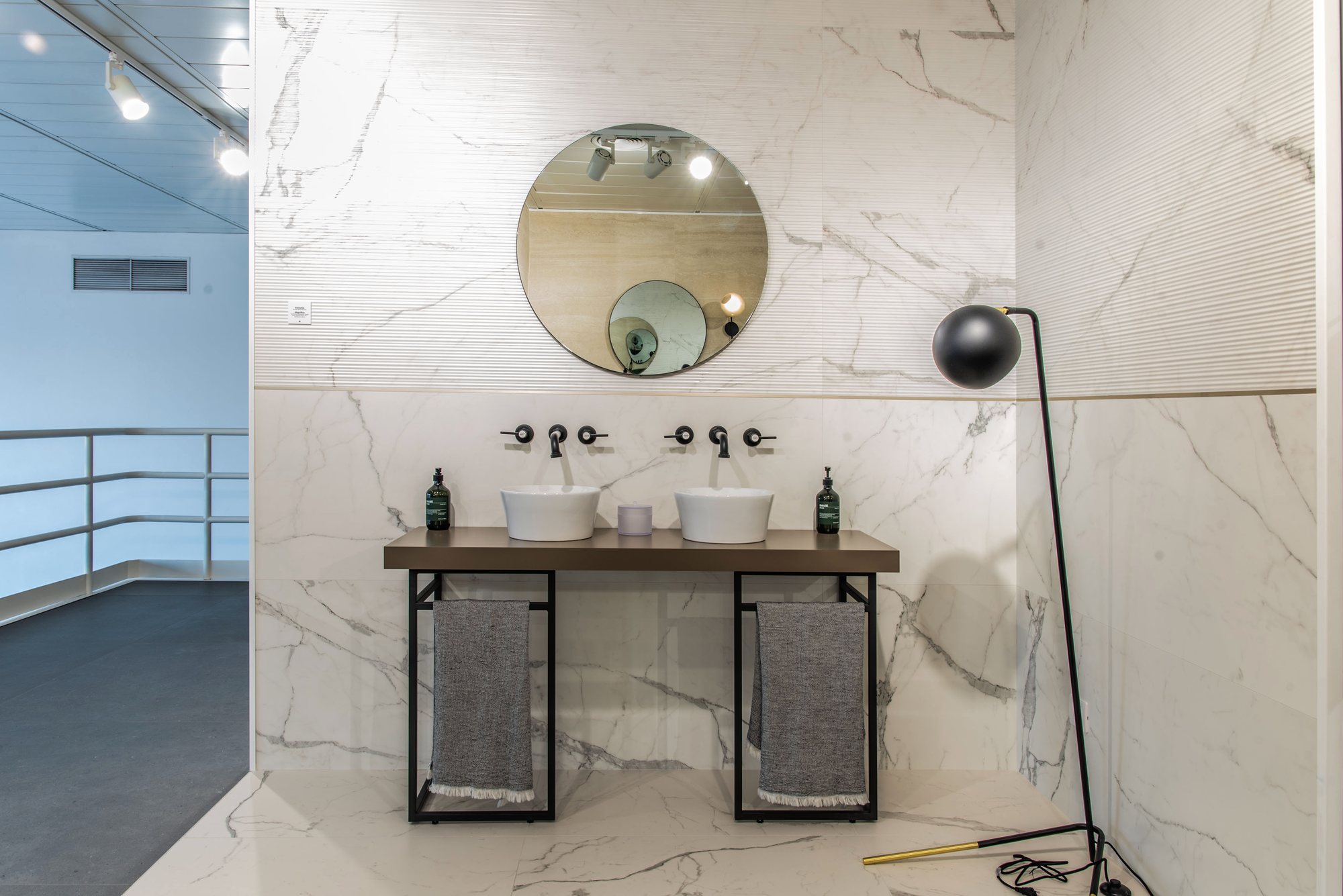 Ambiente de baño con lavabos sobre estructura metálica y mármol