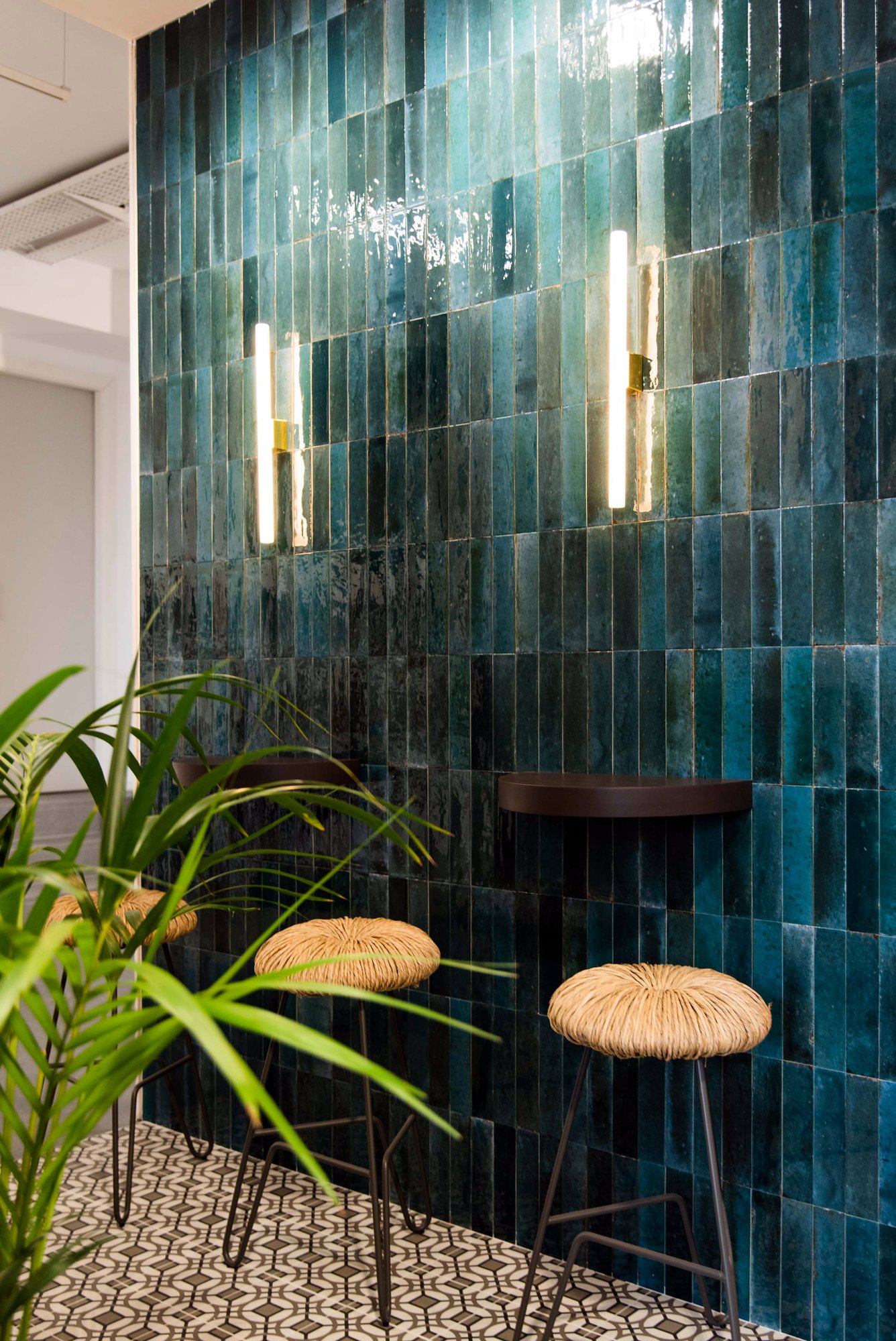 Ambiente con revestimiento verde y taburetes