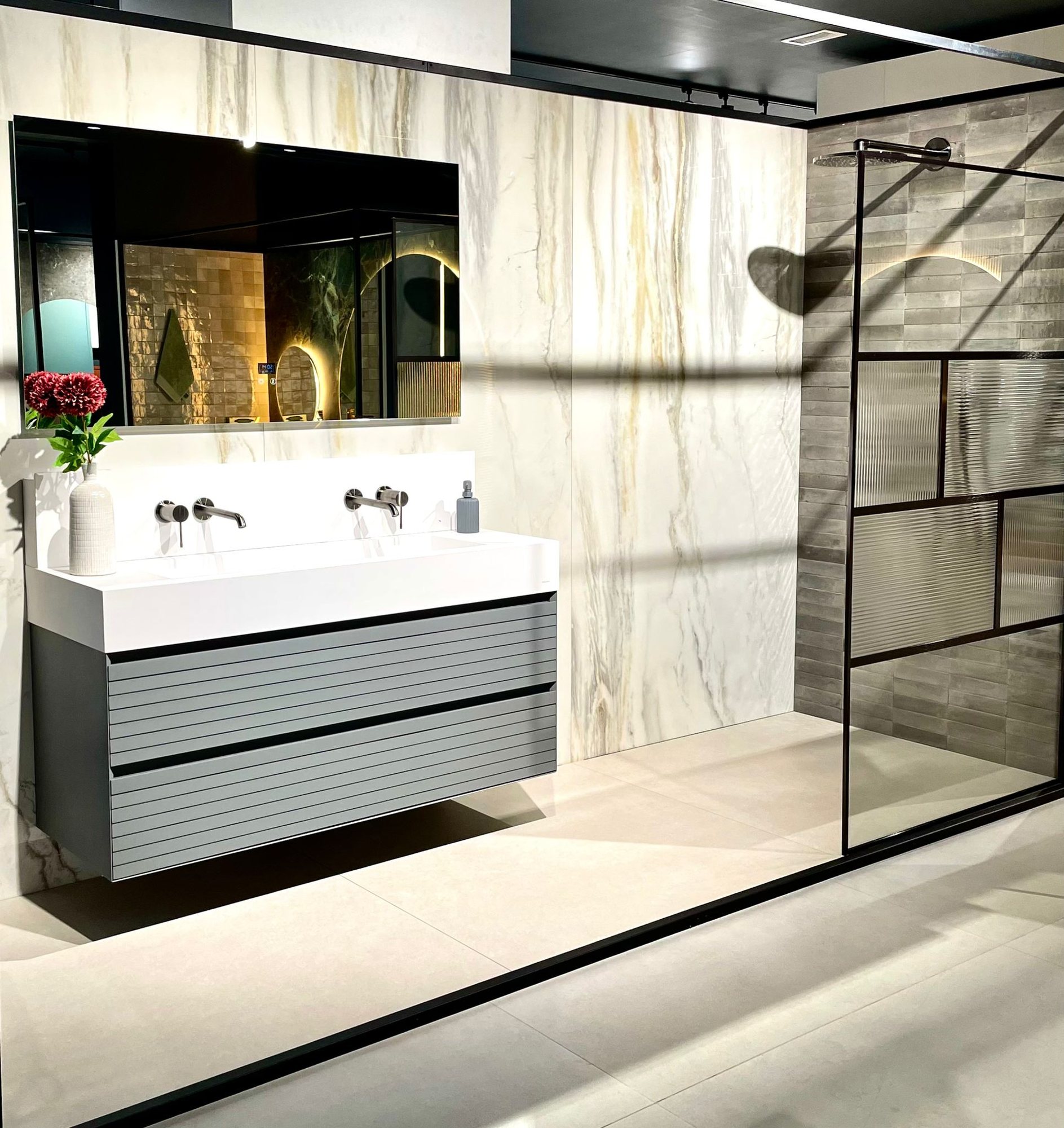 Ambiente con mueble de lavabo y mampara de perfil negro
