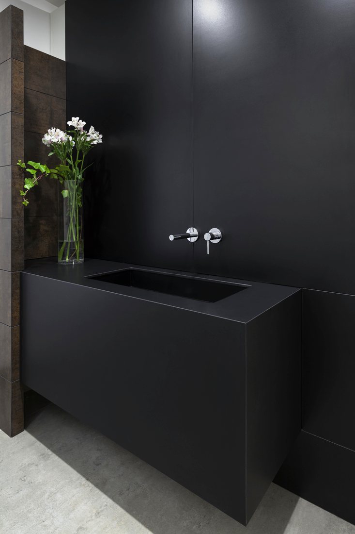 Lavabo negro con grifería empotrada